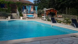 einen Pool mit zwei Stühlen und einem Pavillon in der Unterkunft L'Abrialys in Lorgues