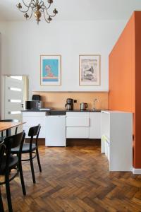 cocina con armarios blancos, mesa y sillas en Apartments Studencka Street, Next to Planty Park en Cracovia