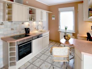 a kitchen with white cabinets and a sink and a table at Ferienwohnungen Haus Angela in Mühlhausen +24 photos