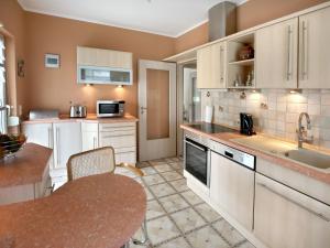 a kitchen with white cabinets and a table and a sink at Ferienwohnungen Haus Angela in Mühlhausen