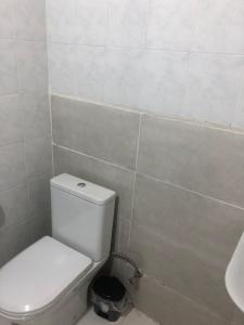 a bathroom with a white toilet and a sink at Hotel Nikea Paradiso in Kutaisi