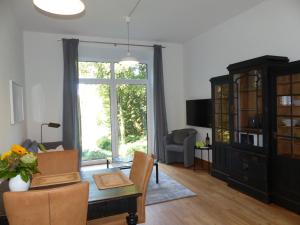 uma sala de estar com uma mesa e uma grande janela em Forstgut Stübeckshorn em Soltau