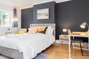 a bedroom with a large bed with a desk and a desk at Charming 2-Bedrooms Apartment with a Garden at Abingdon in Oxford