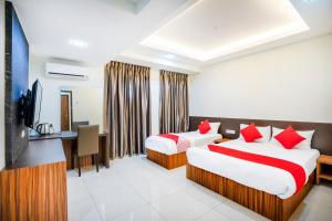 a hotel room with two beds and a television at OYO 428 Hope Hotel in Johor Bahru