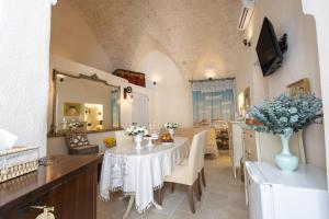 a dining room with a table and a vase of flowers at Suite Cavour 30 in Ostuni +19 photos