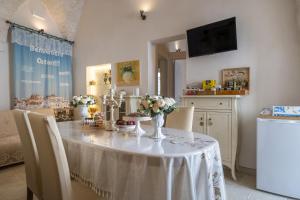a dining room with a table with flowers on it at Suite Cavour 30 in Ostuni +15 photos