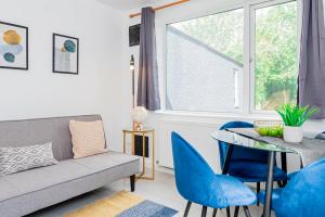 a living room with a couch and a table and chairs at Charming 2-Bedrooms Apartment with a Garden at Abingdon in Oxford