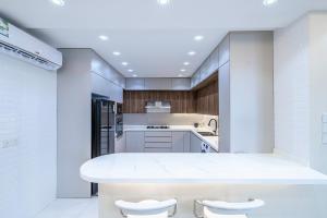 a kitchen with a large white counter and stools at Mabaat - Almasarat Tower Al Shati - 531 in Jeddah