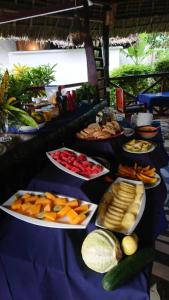 a blue table topped with plates of fruits and vegetables at Highland Bungalows in Nungwi