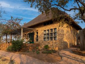a large brick building with a thatched roof at Klipdrift Sands Bush Camp in Dinokeng Game Reserve
