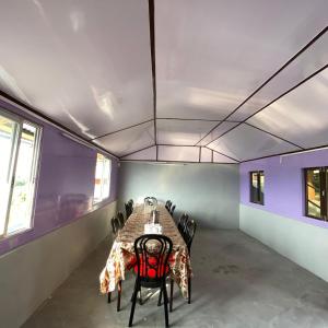a room with a table with chairs and purple walls at Golden Apple Garden Homestay by StayApart in Kalimpong