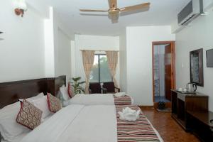 um quarto com uma grande cama branca e uma janela em Hotel Admire Pokhara Pvt. Ltd. em Pokhara