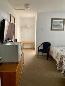 una habitación de hotel con cama y TV en un tocador en Motel 99, en Grand Forks