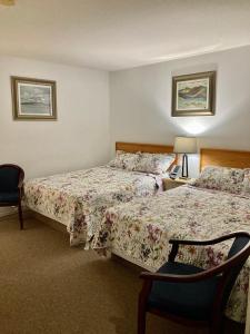 una camera d'albergo con due letti e una sedia di Motel 99 a Grand Forks