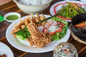 un plato de comida con fideos y papas fritas en Hodota Cam Bình Resort & Spa - Lagi Beach en Vĩnh Thạnh