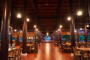 une salle à manger avec des tables, des chaises et des lumières dans l'établissement Hodota Cam Bình Resort & Spa - Lagi Beach, à Vĩnh Thạnh