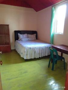sypialnia z łóżkiem, krzesłem i oknem w obiekcie Endi Surf Camp w mieście Lagudri