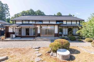 a house with a garden in front of it at 佐渡古民家ステイ さどまり -Sadomari Historical Villa- in Sado