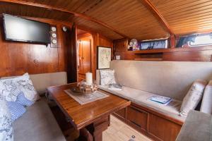 a dining room in a train with a table and a tv at Quo Vadis Yacht in Bari
