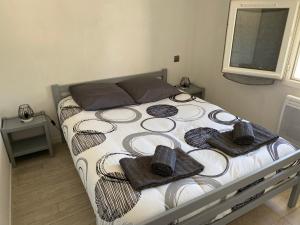 1 dormitorio con 1 cama con toallas en Maison à 300 m de la plage. en La Cotinière