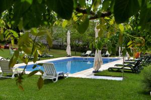 a swimming pool with lounge chairs and umbrellas at Casa do Médico in Carção