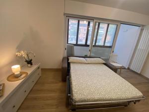 a bedroom with two beds and a table and windows at Basiglio - Residenza Sorgente in Basiglio