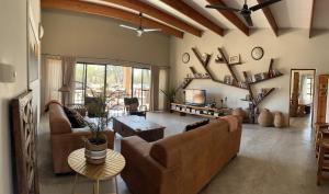 a living room with two couches and a tv at Mananga Bush Villa in Skukuza