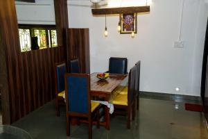 a dining room with a wooden table and chairs at 6Tamarind in Gholvad