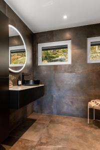 a bathroom with a sink and two windows at Enebolig høy standard, sjøutsikt in Tokenes