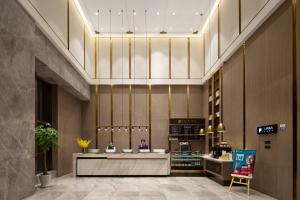 a lobby of a store with two people sitting at a counter at ECHARM Plus Hotel - Hangzhou Binjiang Starlight Avenue in Hangzhou