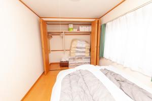 a small bedroom with a bed and a window at Restful Tsukuda in Aomori