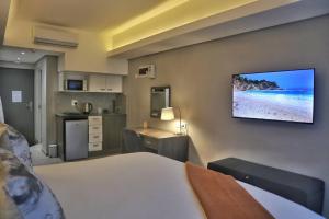 a bedroom with a bed and a television on a wall at Foreshore Winks 407 in Cape Town