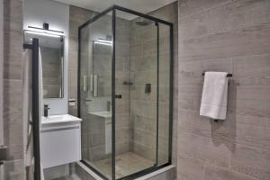 a glass shower in a bathroom with a sink at Foreshore Winks 407 in Cape Town