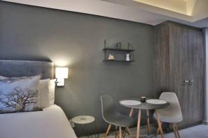 a bedroom with a bed and a table and chairs at Foreshore Winks 407 in Cape Town