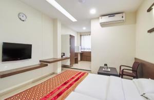 Habitación de hotel con cama y TV de pantalla plana. en Hotel Girnar, en Aurangabad