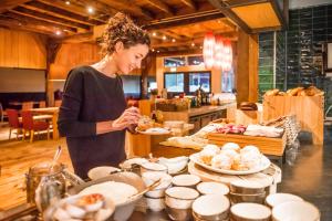 a woman standing in a kitchen preparing food at Erfgoed Bossem in Lattrop