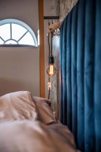 a bedroom with a bed with a lamp next to a window at Erfgoed Bossem in Lattrop