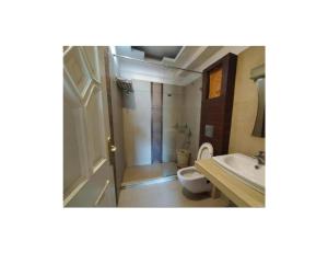 a bathroom with a toilet and a sink at Hotel Shambhavi, Singrauli in Singrauli