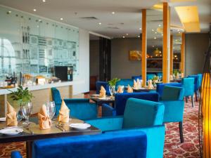 クチンにあるThe Waterfront Hotel Kuchingの青い椅子とテーブルのあるレストラン