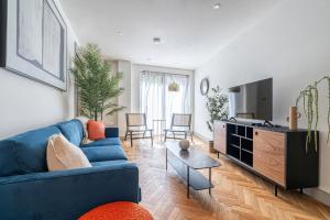 un soggiorno con un divano blu e una TV di Luxury flats near Big Ben and London Eye a Londra Altre 37 foto