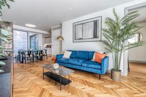 a living room with a blue couch and a table at Luxury flats near Big Ben and London Eye in London +267 photos