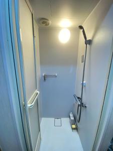 ein Bad mit einer Dusche und einem WC mit einer Lampe in der Unterkunft Guesthouse Imaichi ゲストハウス今市マチナカ in Nikko