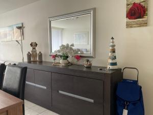 a dresser in a living room with a mirror at Micheline's plekje in Ostend