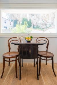 a table with two chairs and a bowl of fruit on it at La Casa del Sarto Amalfi in Amalfi