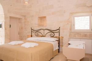 1 Schlafzimmer mit 2 Betten in einer Steinwand in der Unterkunft Trullo Cinquenoci Suite in Locorotondo