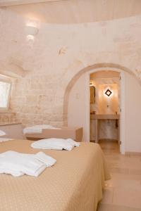 1 Schlafzimmer mit 2 Betten und einer Steinmauer in der Unterkunft Trullo Cinquenoci Suite in Locorotondo