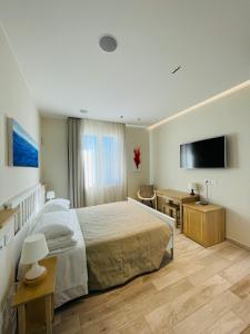 Un dormitorio con una cama, un escritorio y un televisor. en Camere Paolina, en Foligno