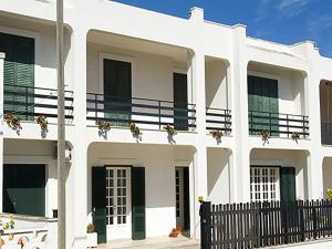 - un bâtiment blanc avec des fleurs sur les balcons dans l'établissement Casa Dani, à Cerfignano