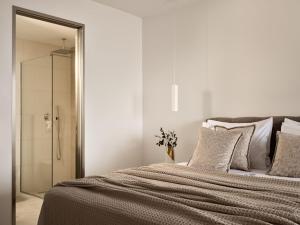 1 dormitorio con 1 cama y ducha acristalada en The Sall Suites - Complex B en Agios Nikolaos