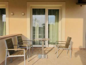 Dos sillas y una mesa frente a una ventana. en Camere Paolina, en Foligno